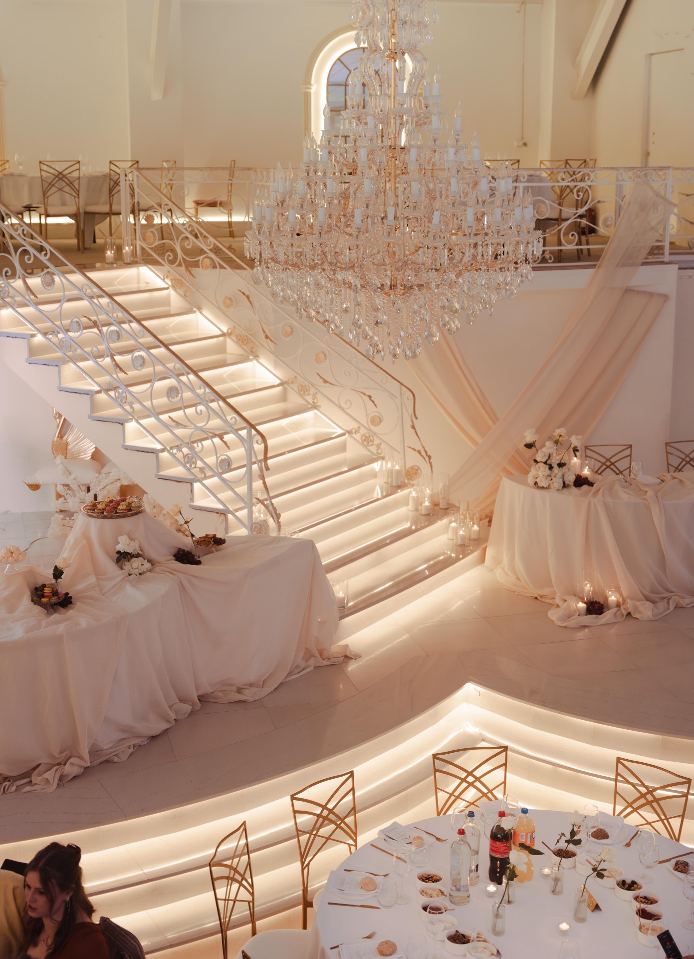 Interieur van WOW Feestzaal met kroonluchter, verlichte trap en elegante gordijndrapes